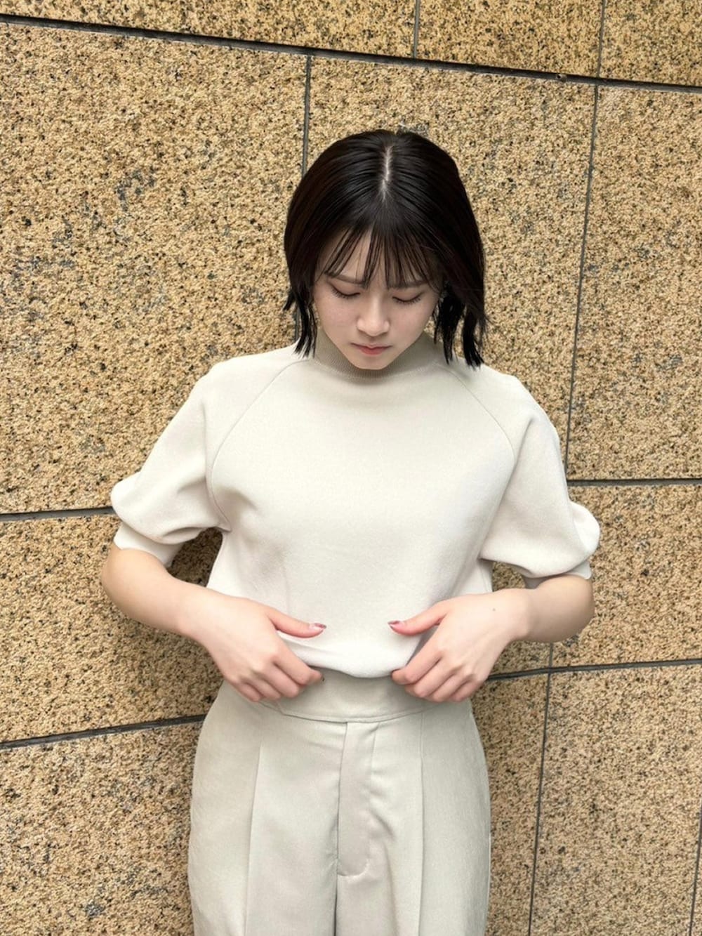 ベージュ系のニット/セーター、ベージュ系のスラックスを着用したレディースの春コーディネートの5枚目の写真