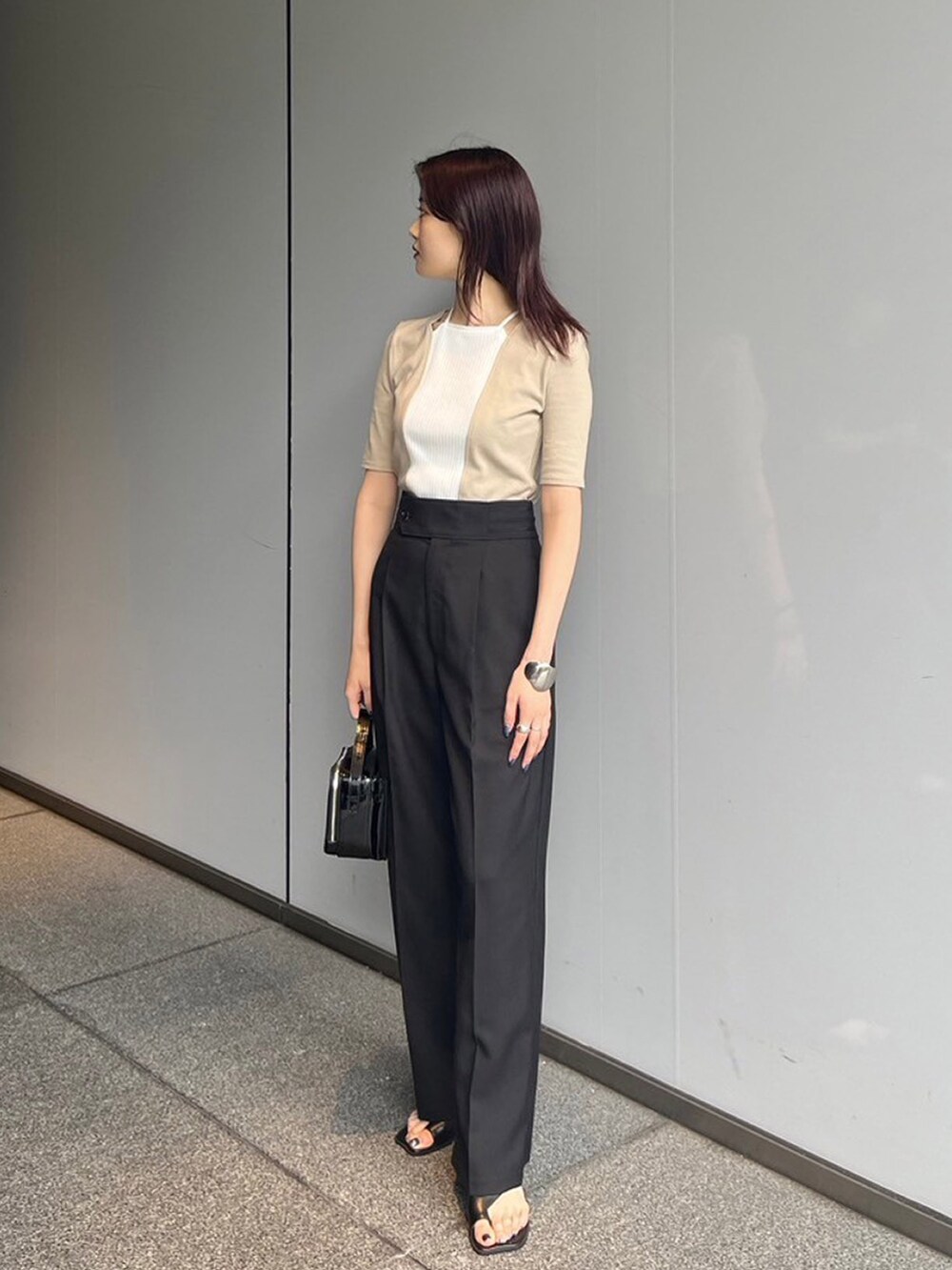 ベージュ系のTシャツ/カットソー、ブラック系のスラックスを着用したレディースの夏コーディネートの3枚目の写真