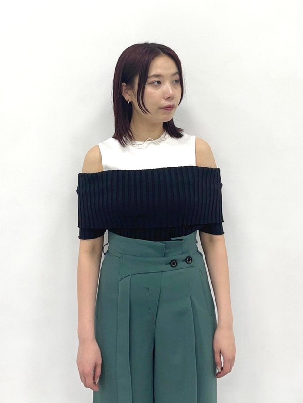 グリーン系のスラックス、ブラック系のニット/セーターを着用したレディースの春コーディネートの5枚目の写真