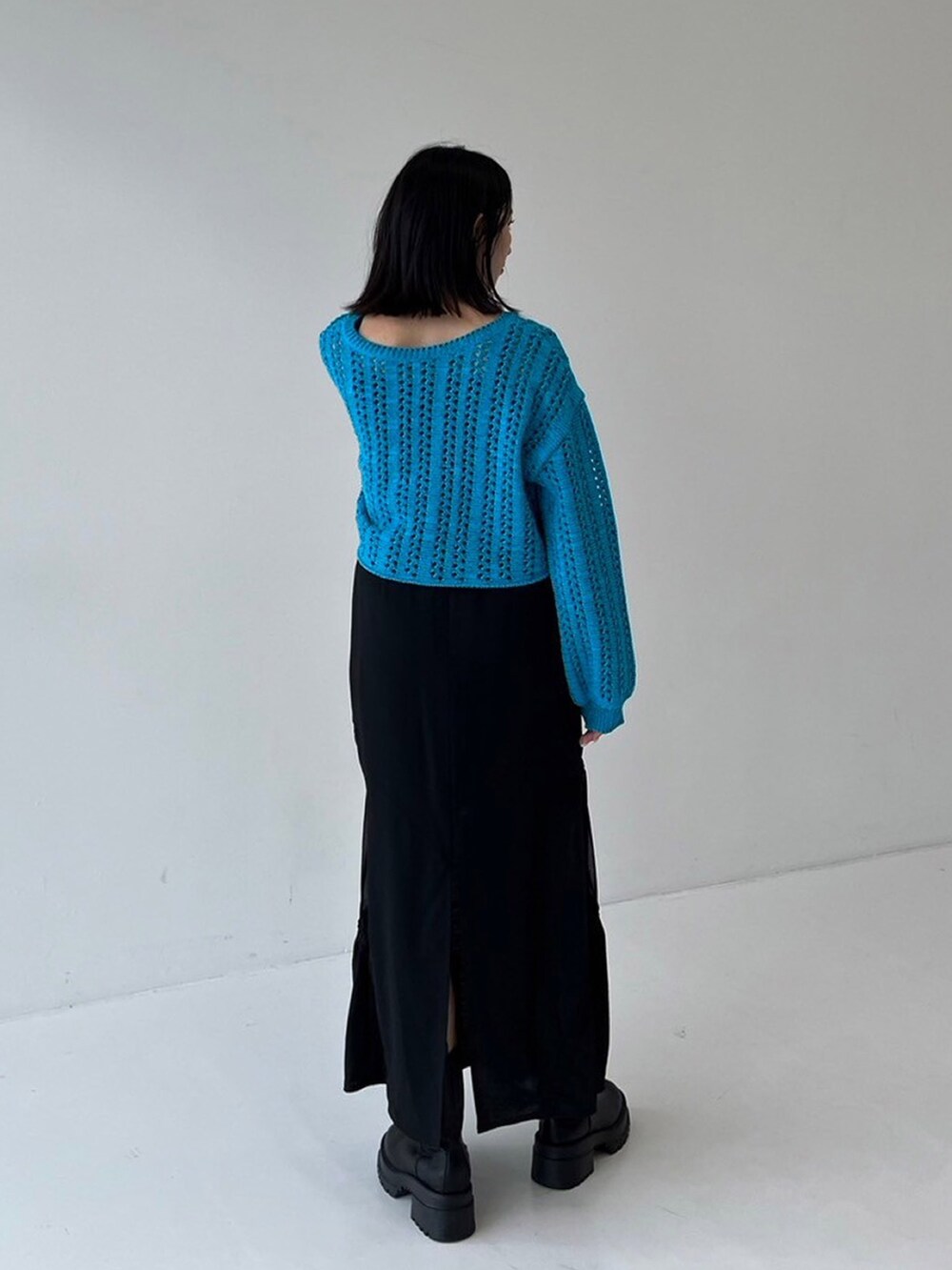 ブルー系のニット/セーター、ブラック系のスカートを着用したレディースの秋コーディネートの3枚目の写真