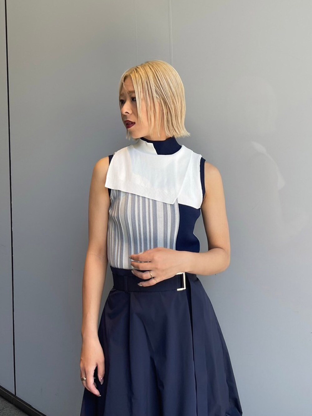 ブルー系のニット/セーター、ブルー系のスカートを着用したレディースの夏コーディネートの2枚目の写真