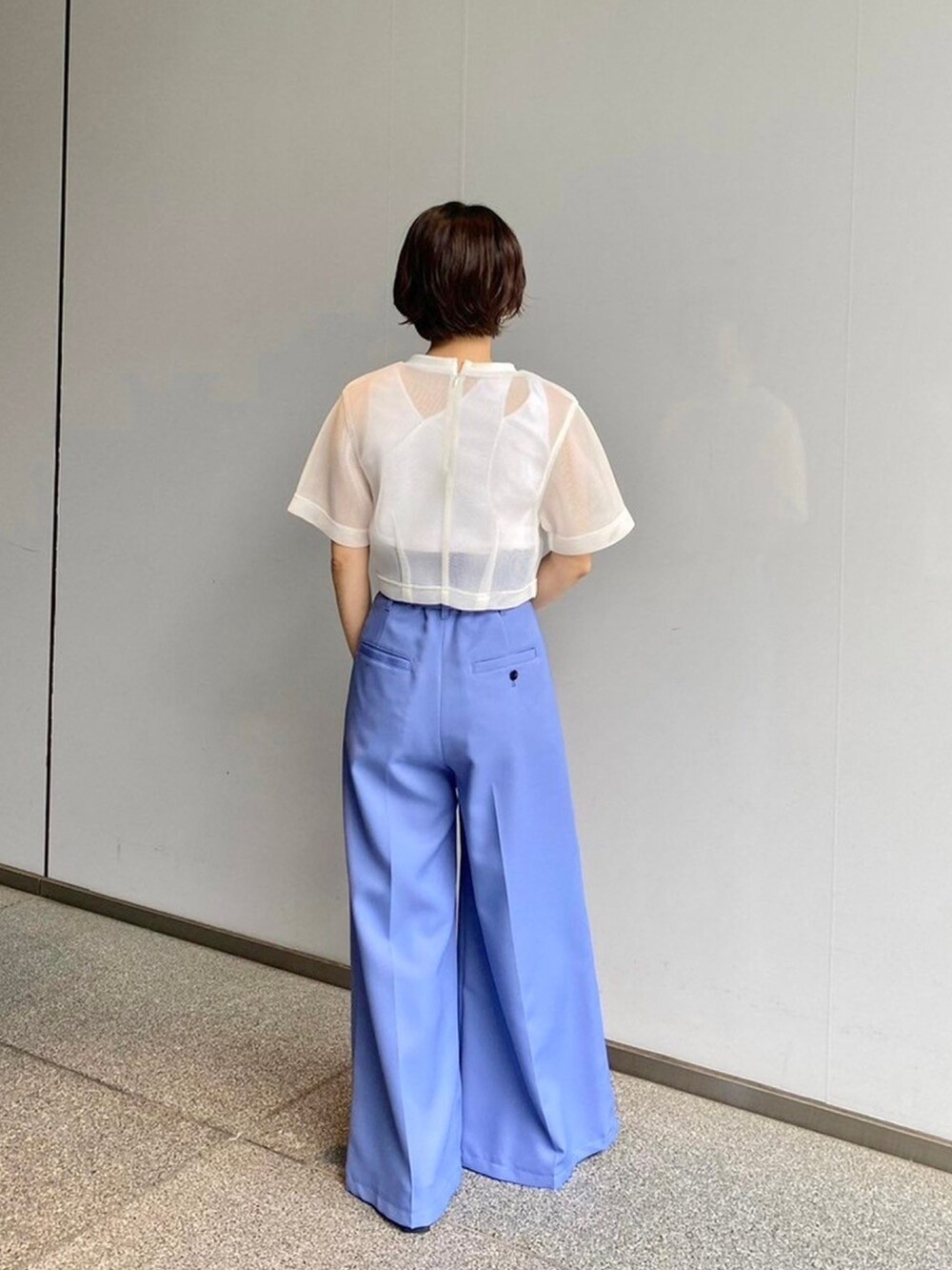 ホワイト系のシャツ/ブラウス、ブルー系のスラックスを着用したレディースの春コーディネートの3枚目の写真