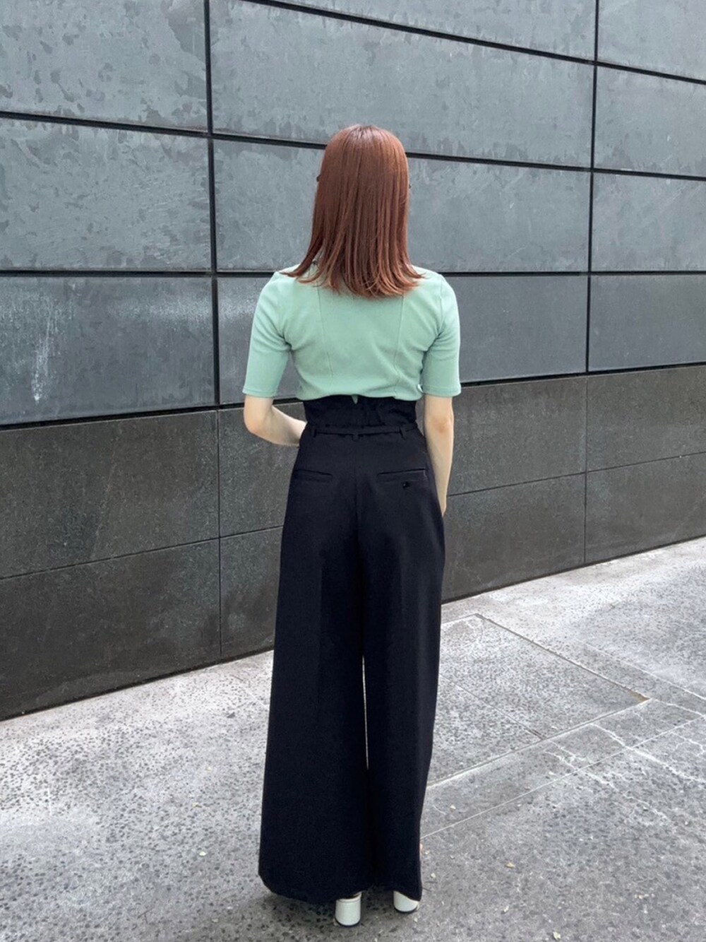 グリーン系のTシャツ/カットソー、ブラック系のスラックスを着用したレディースの夏コーディネートの3枚目の写真