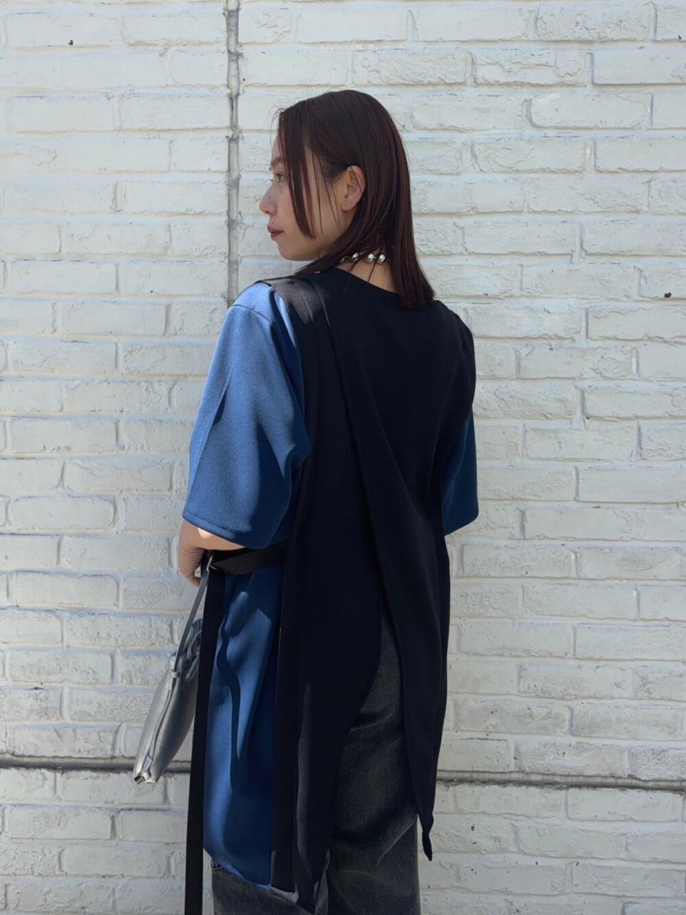 ブラック系のTシャツ/カットソー、ブラック系のデニムパンツを着用したレディースの春コーディネートの6枚目の写真