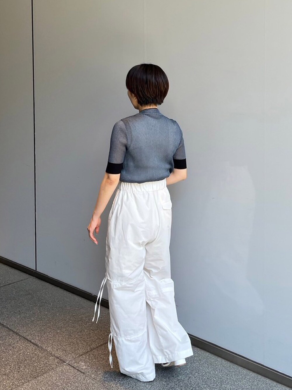 ブルー系のニット/セーター、ホワイト系のその他パンツを着用したレディースの夏コーディネートの2枚目の写真