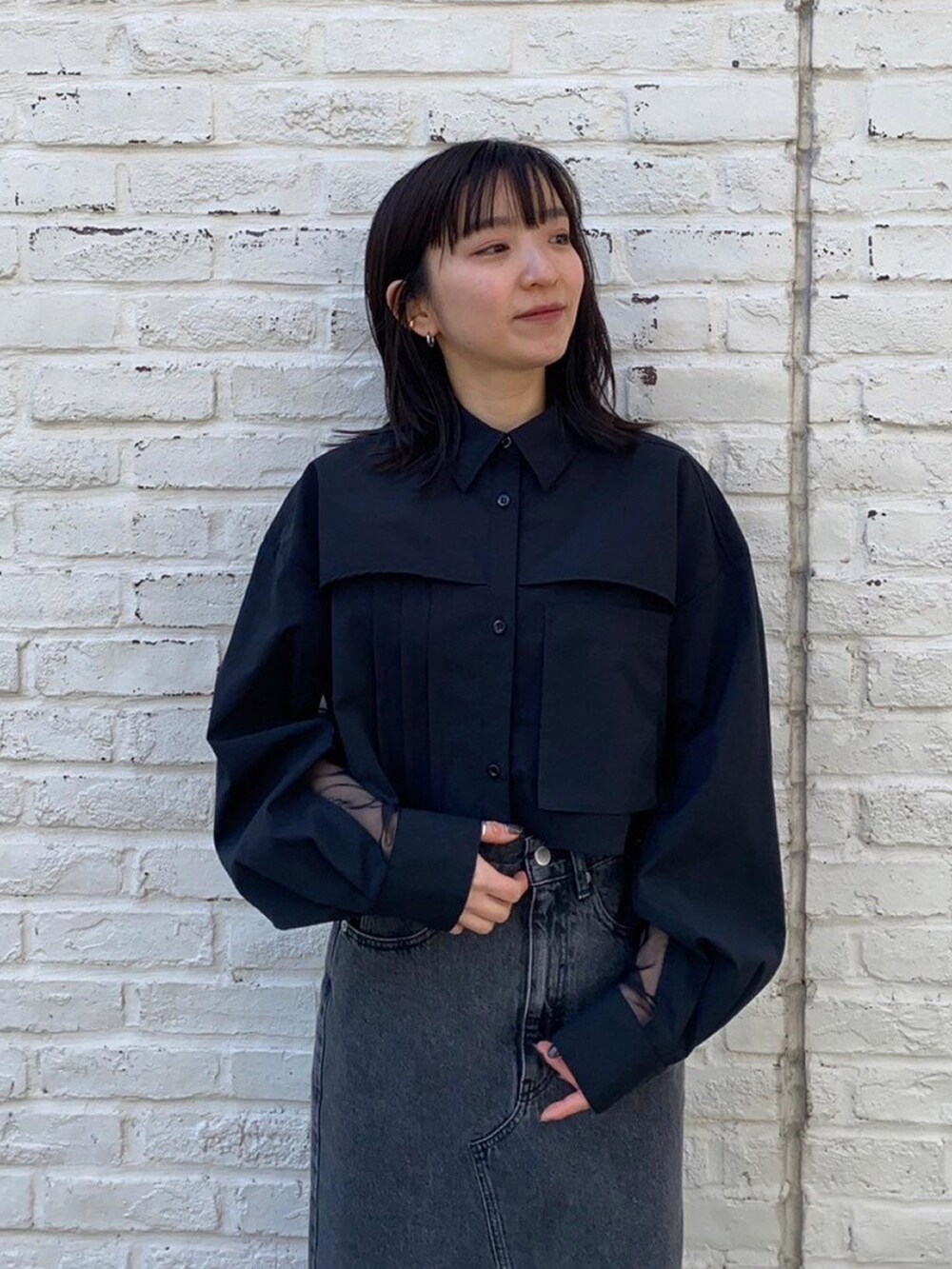 ブラック系のシャツ/ブラウス、ブラック系のデニムスカートを着用したレディースの春コーディネートの5枚目の写真