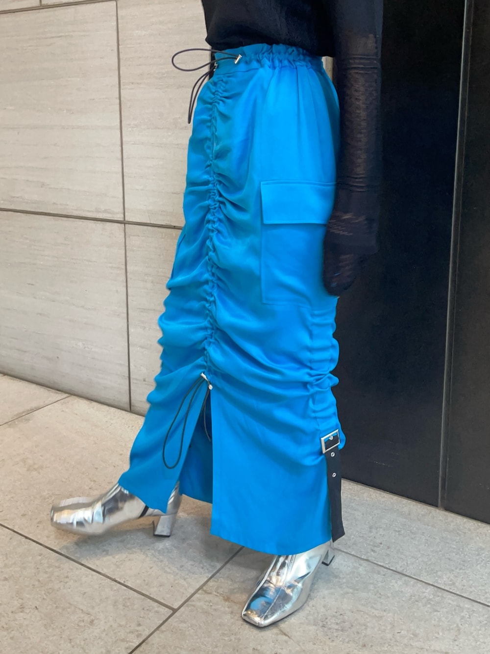 ブラック系のニット/セーター、ブルー系のスカートを着用したレディースの春コーディネートの7枚目の写真