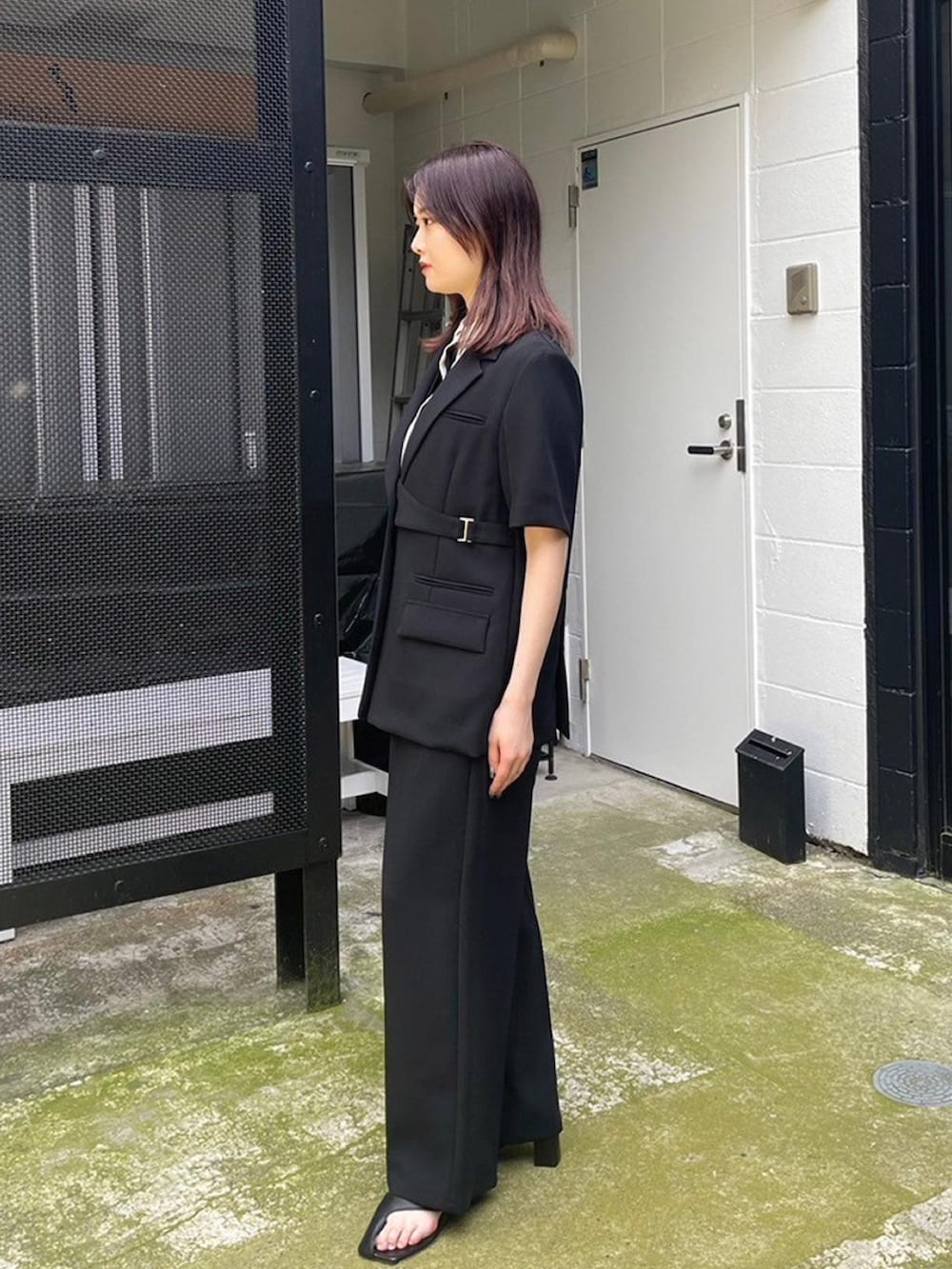 ブラック系のスラックス、ブラック系のテーラードジャケット、ベージュ系のシャツ/ブラウスを着用したレディースの春コーディネートの2枚目の写真