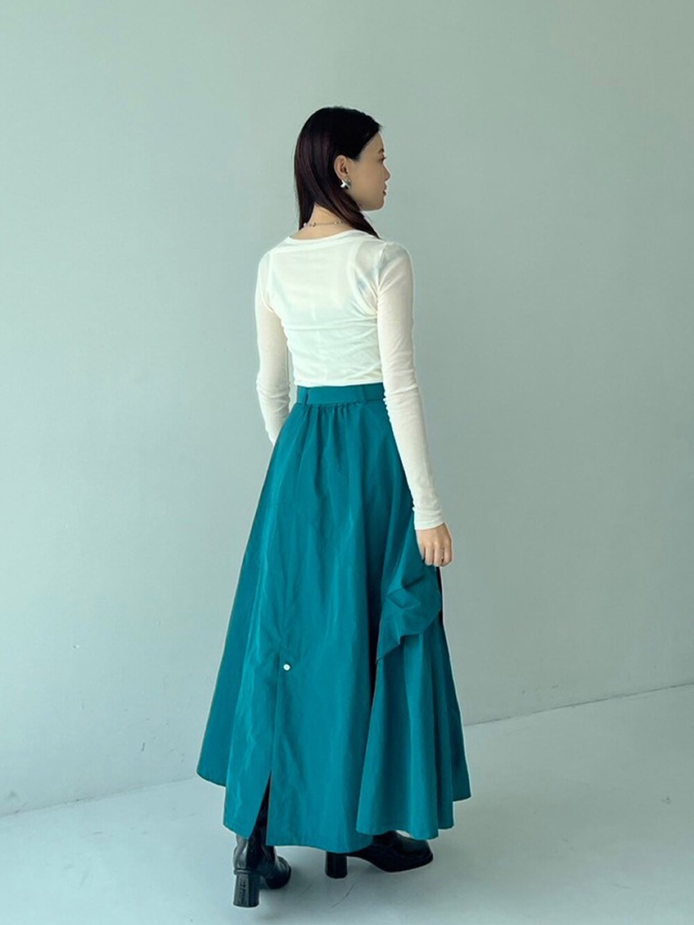 ホワイト系のTシャツ/カットソー、グリーン系のスカートを着用したレディースの秋コーディネートの2枚目の写真