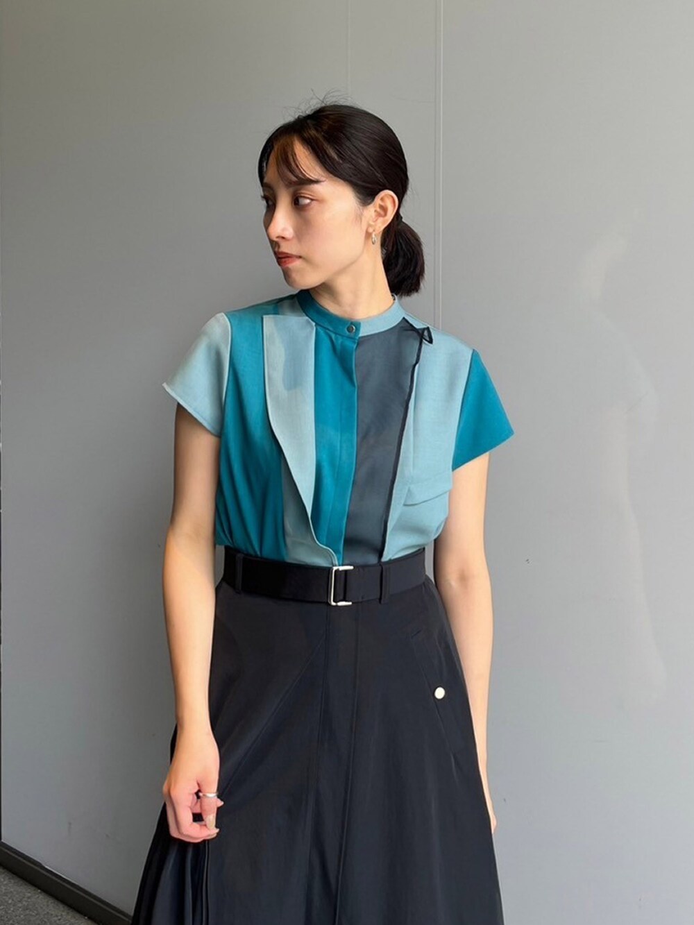 グリーン系のシャツ/ブラウス、ブラック系のスカートを着用したレディースの夏コーディネートの4枚目の写真