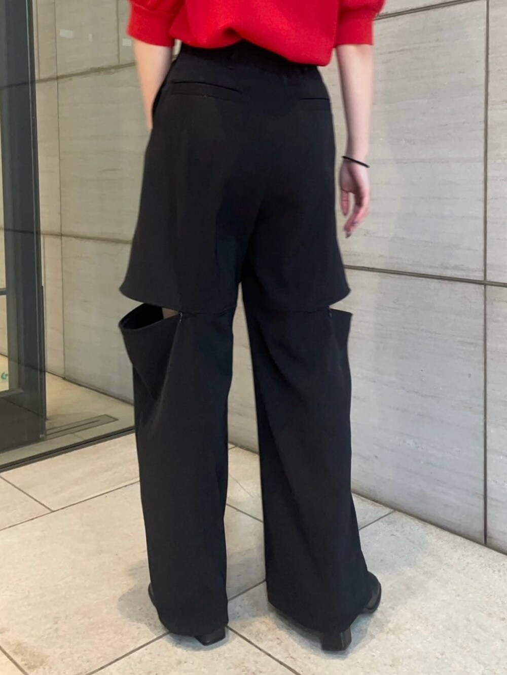 レッド系のニット/セーター、ブラック系のその他パンツを着用したレディースの春コーディネートの6枚目の写真