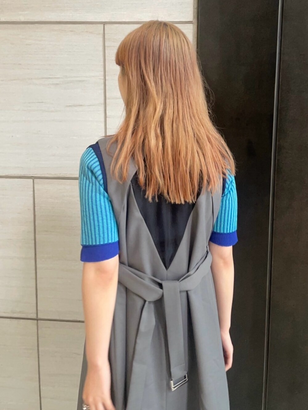 グレー系のジャンパースカートを着用したレディースの春コーディネートの6枚目の写真