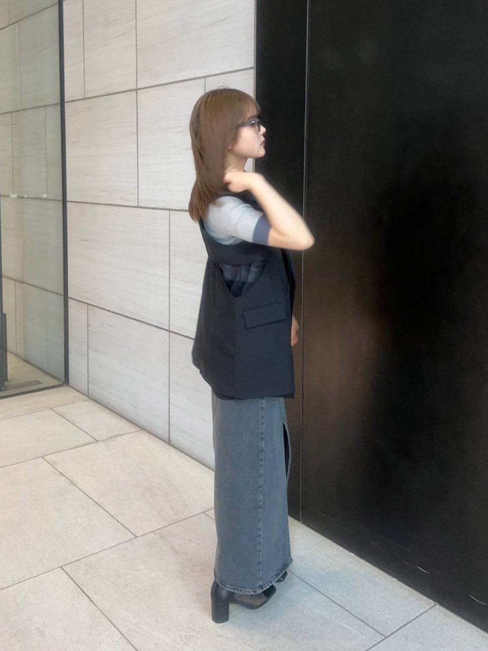 ブラック系のベストを着用したレディースの春コーディネートの4枚目の写真