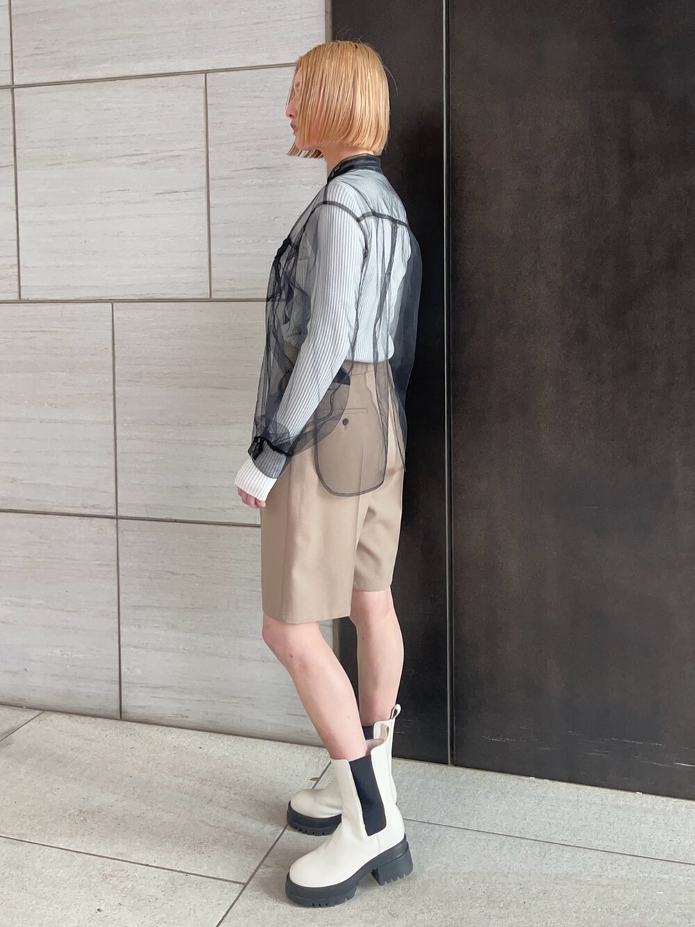 ブラック系のシャツ/ブラウス、ホワイト系のニット/セーター、ベージュ系のその他パンツを着用したレディースの春コーディネートの2枚目の写真