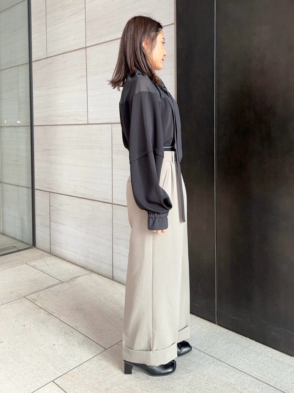 ブラック系のシャツ/ブラウス、ベージュ系のその他パンツを着用したレディースの春コーディネートの2枚目の写真