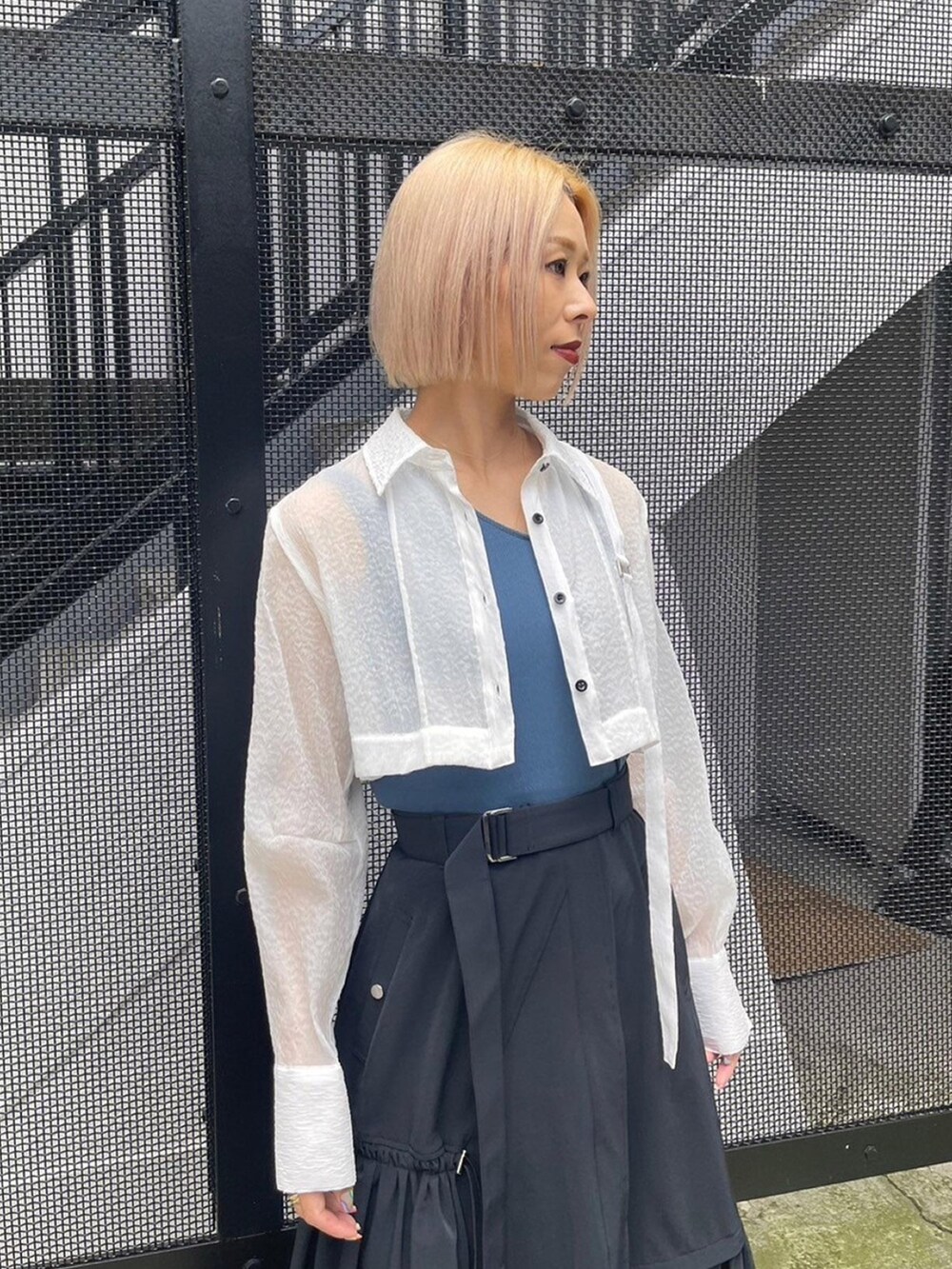 ホワイト系のシャツ/ブラウス、ブルー系のタンクトップ、ブラック系のスカートを着用したレディースの春コーディネートの5枚目の写真