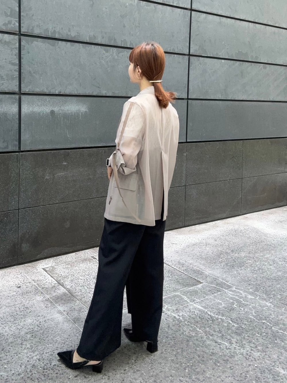 ベージュ系のテーラードジャケット、ホワイト系のTシャツ/カットソー、ブラック系のスラックスを着用したレディースの夏コーディネートの2枚目の写真