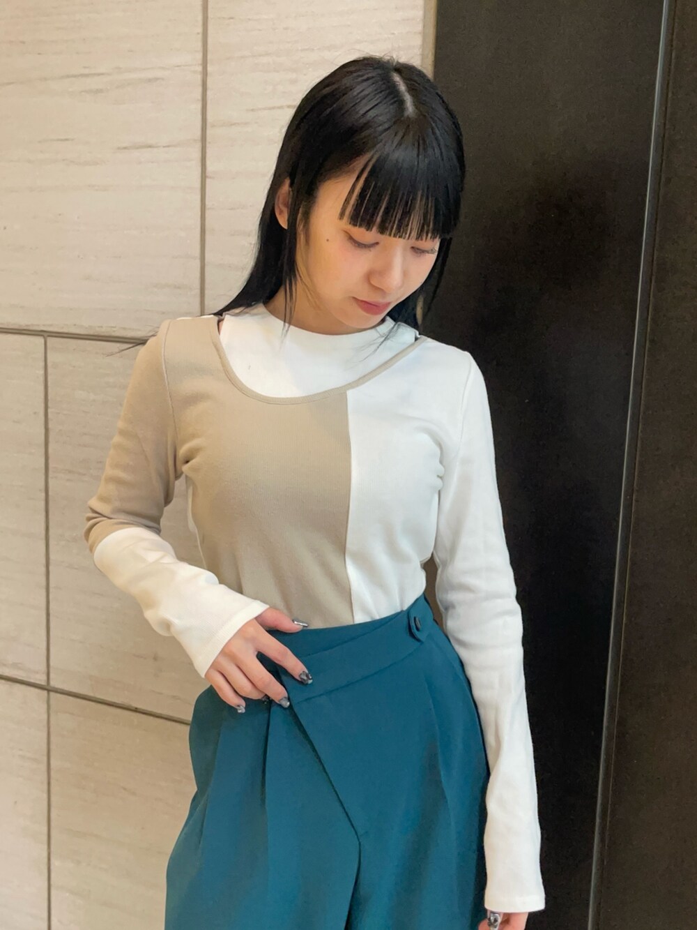 ベージュ系のTシャツ/カットソー、グリーン系のスラックスを着用したレディースの春コーディネートの3枚目の写真