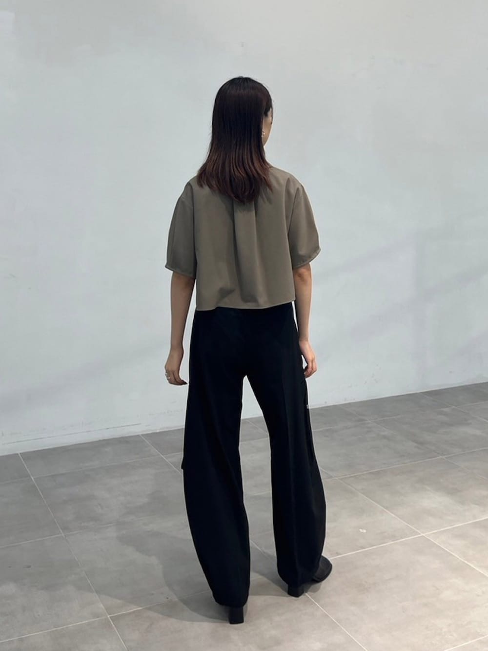 グリーン系のワンピース、ブラック系のその他パンツを着用したレディースの秋コーディネートの3枚目の写真