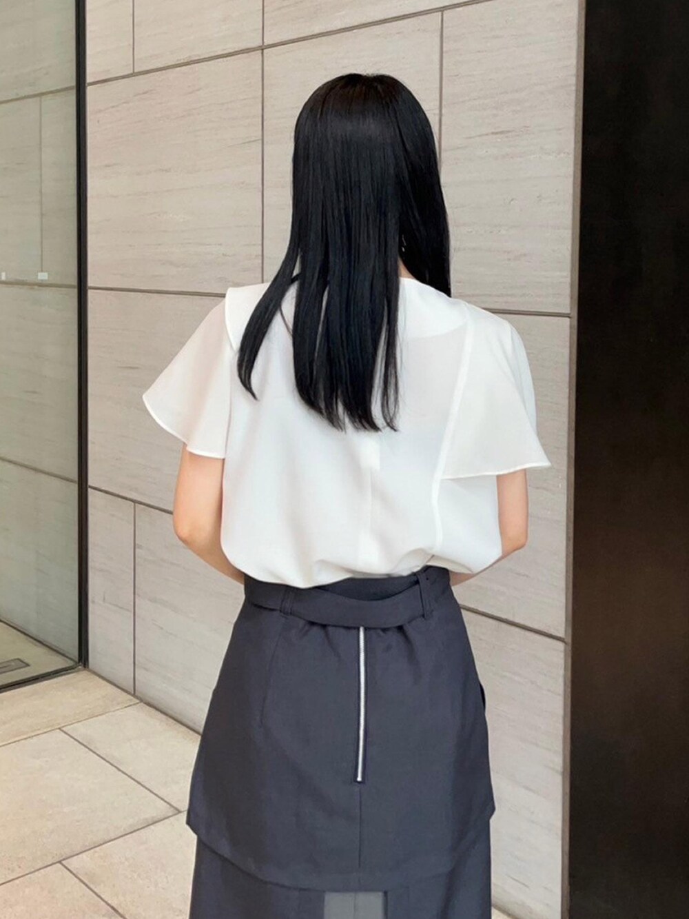 ホワイト系のシャツ/ブラウス、グレー系のスカートを着用したレディースの春コーディネートの6枚目の写真