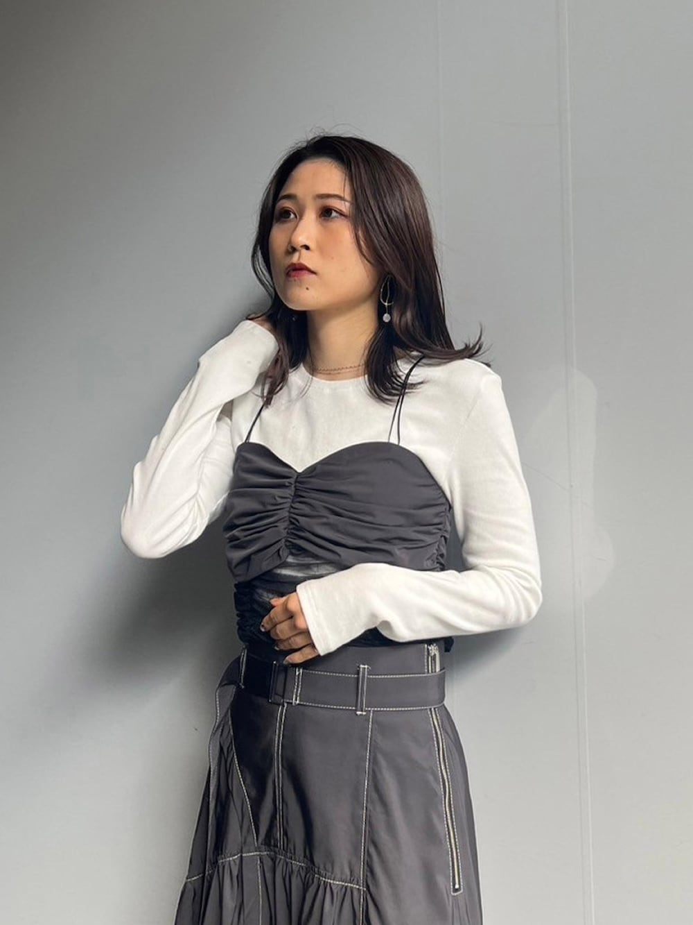 ホワイト系のTシャツ/カットソー、グレー系のスカートを着用したレディースの秋コーディネートの4枚目の写真