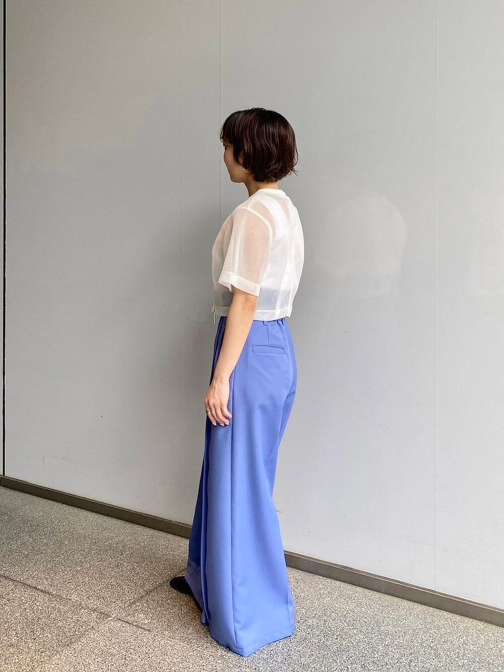 ホワイト系のシャツ/ブラウス、ブルー系のスラックスを着用したレディースの春コーディネートの2枚目の写真