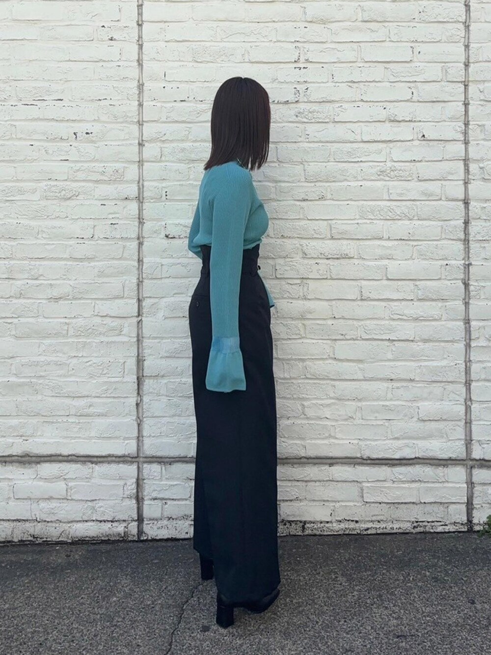ブルー系のニット/セーター、ブラック系のスラックスを着用したレディースの春コーディネートの4枚目の写真