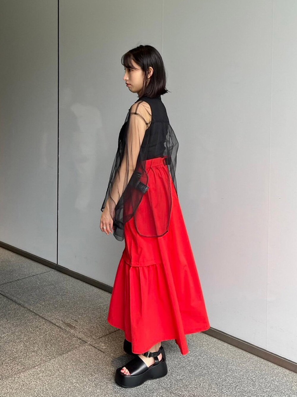 ブラック系のシャツ/ブラウス、ブラック系のタンクトップ、レッド系のスカートを着用したレディースの夏コーディネートの2枚目の写真