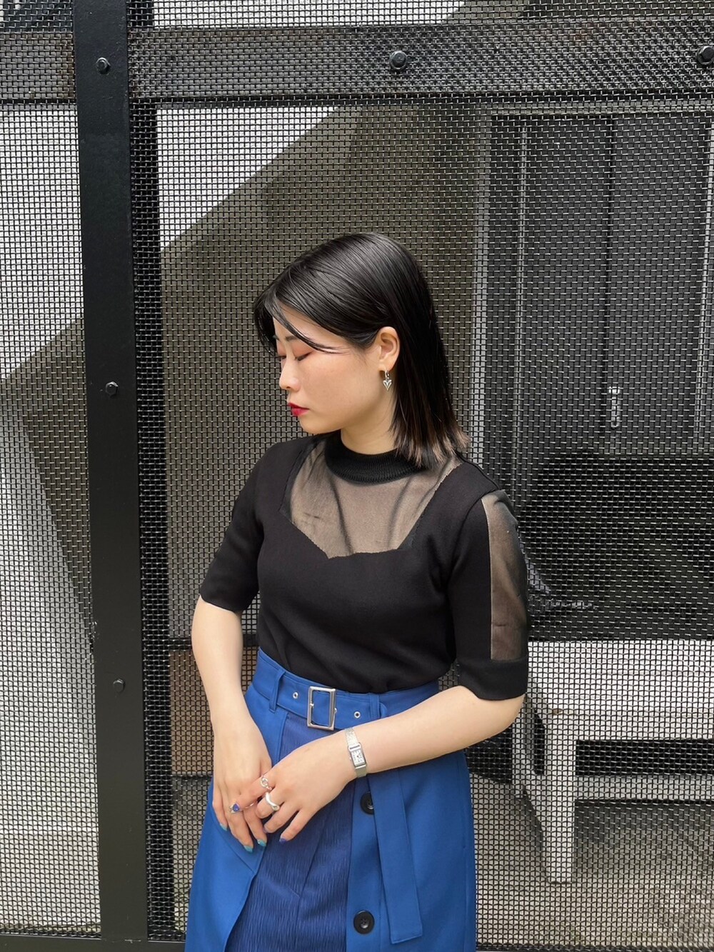 ブラック系のニット/セーター、ブルー系のスカートを着用したレディースの春コーディネートの4枚目の写真