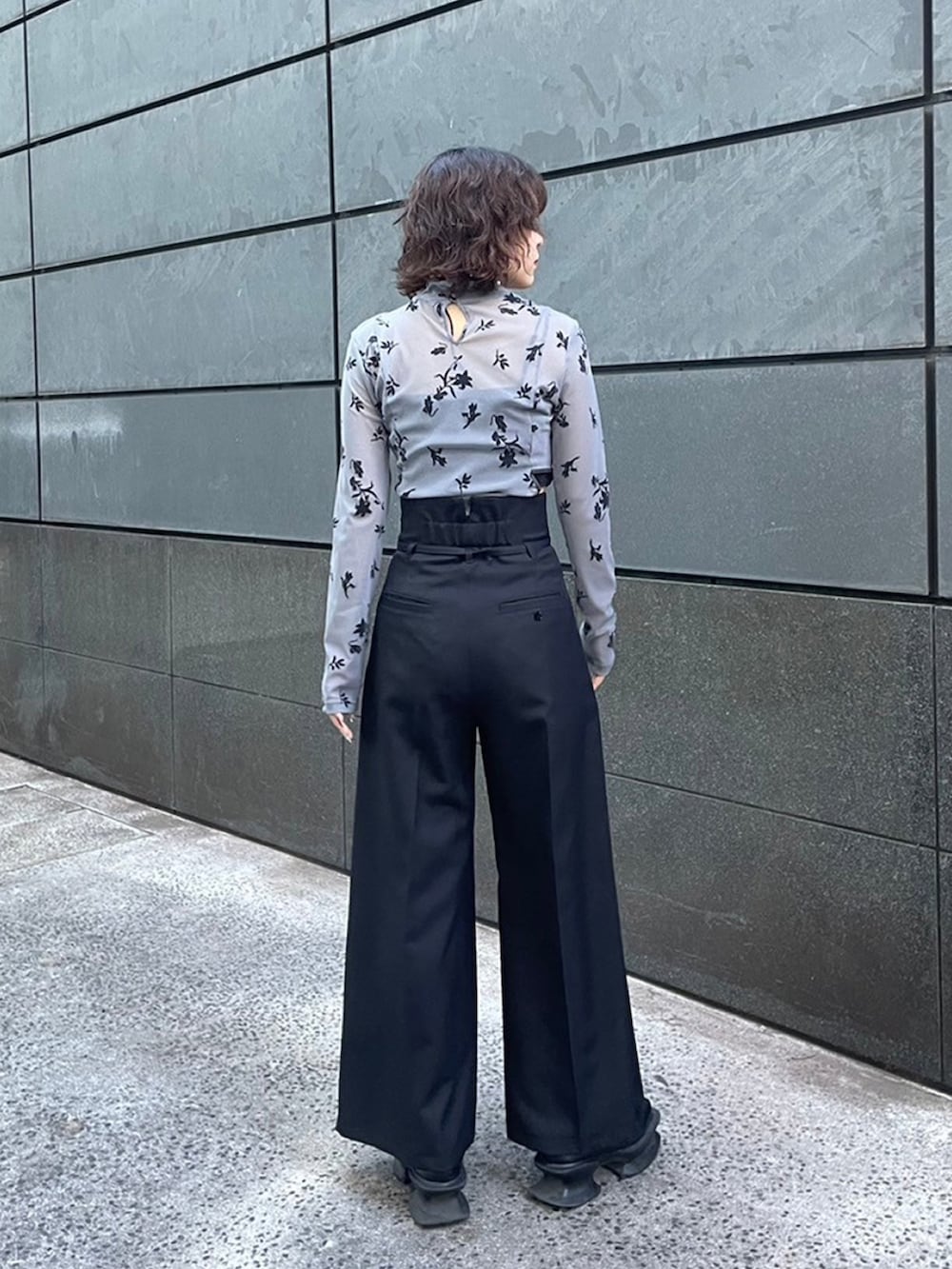 グレー系のTシャツ/カットソー、ブラック系のスラックスを着用したレディースの秋コーディネートの2枚目の写真