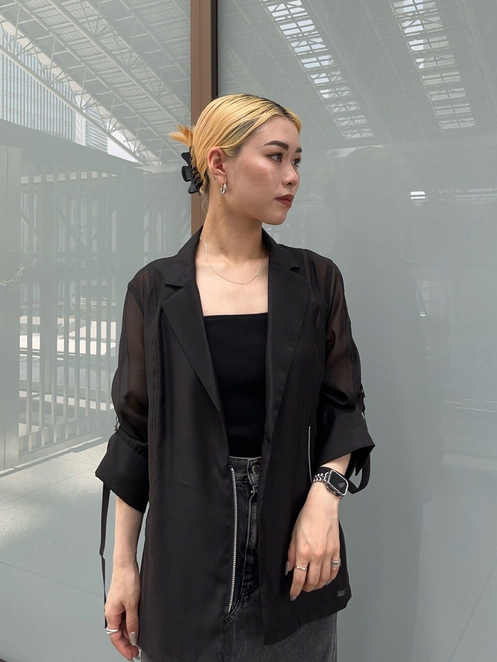 ブラック系のテーラードジャケット、ブラック系のデニムスカートを着用したレディースの夏コーディネートの4枚目の写真