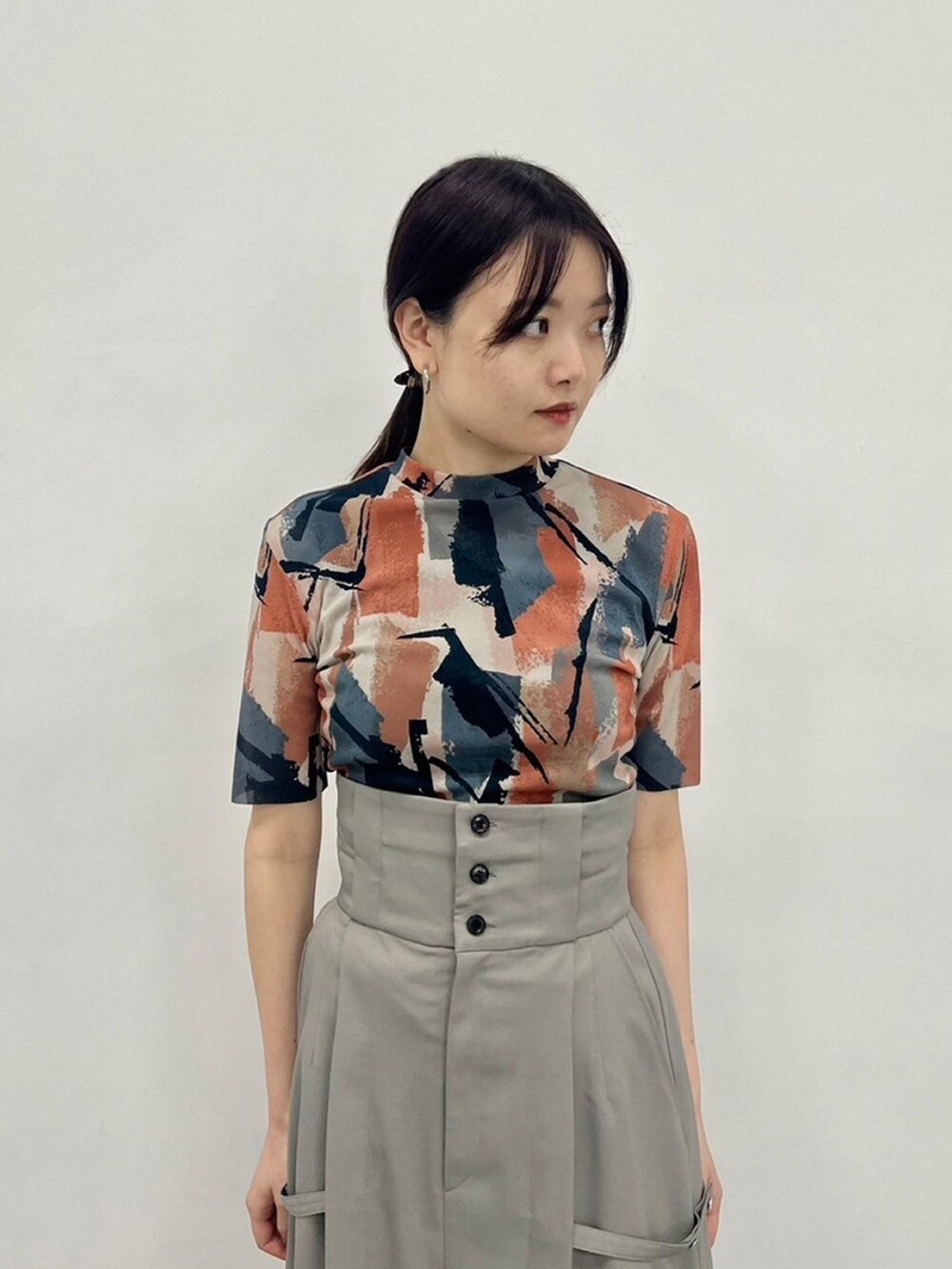 ベージュ系のTシャツ/カットソー、グレー系のスカートを着用したレディースの春コーディネートの6枚目の写真