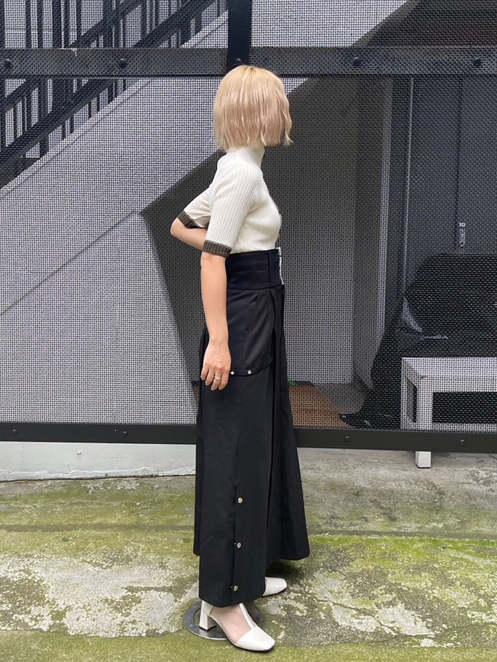 ホワイト系のニット/セーター、ブラック系のスカートを着用したレディースの夏コーディネートの2枚目の写真