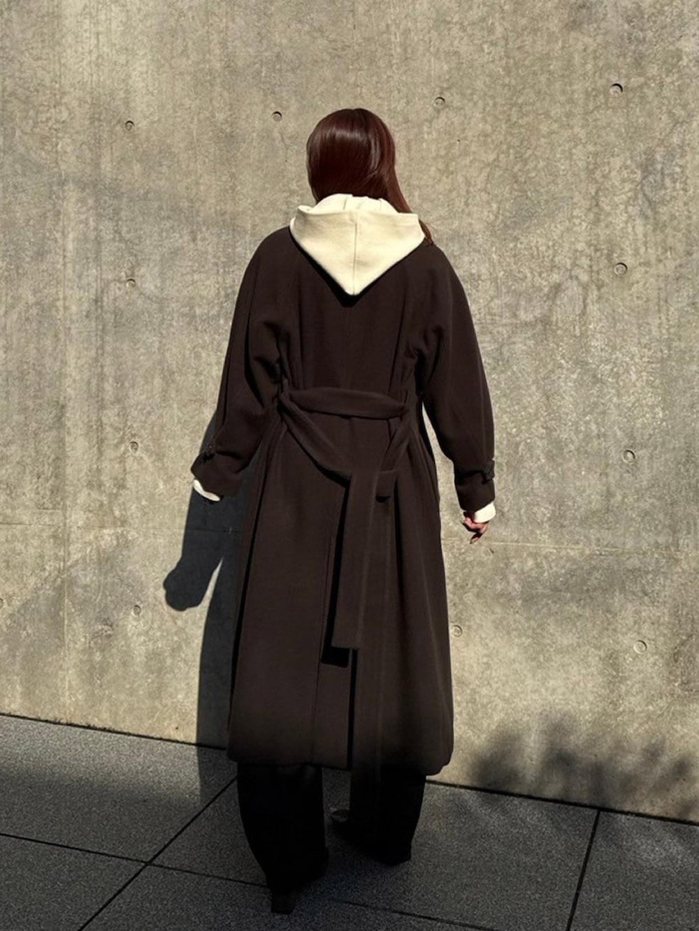 ブラウン系のステンカラーコートを着用したレディースの秋コーディネートの3枚目の写真