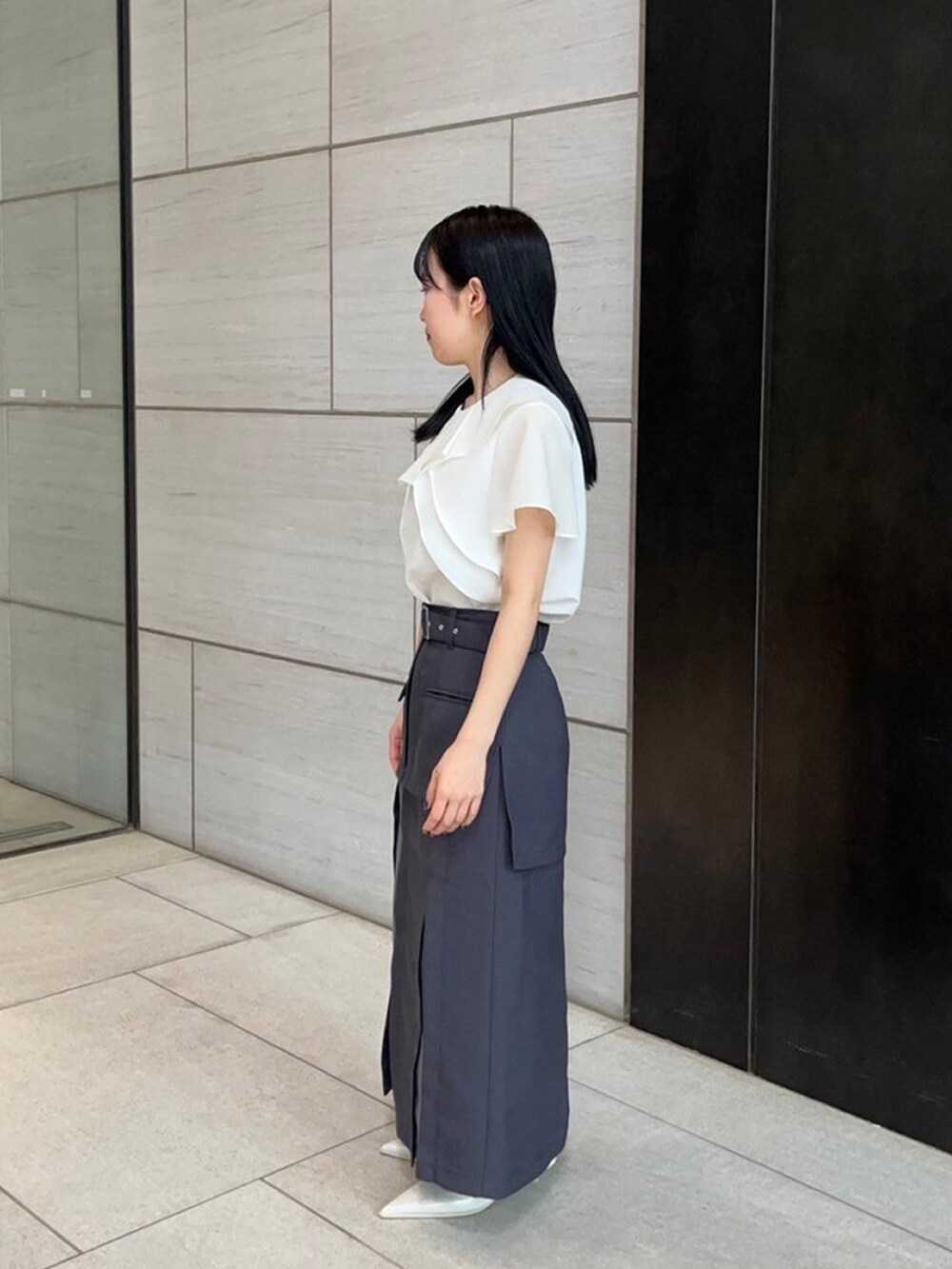 ホワイト系のシャツ/ブラウス、グレー系のスカートを着用したレディースの春コーディネートの2枚目の写真