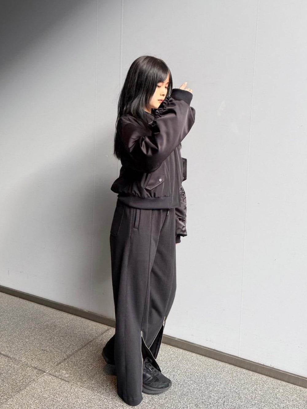 ブラック系のブルゾンを着用したレディースの秋コーディネートの2枚目の写真