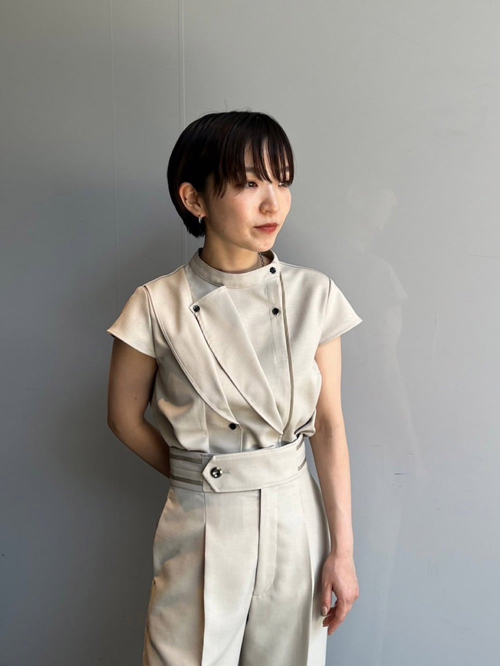 ベージュ系のシャツ/ブラウス、ベージュ系のスラックスを着用したレディースの夏コーディネートの3枚目の写真