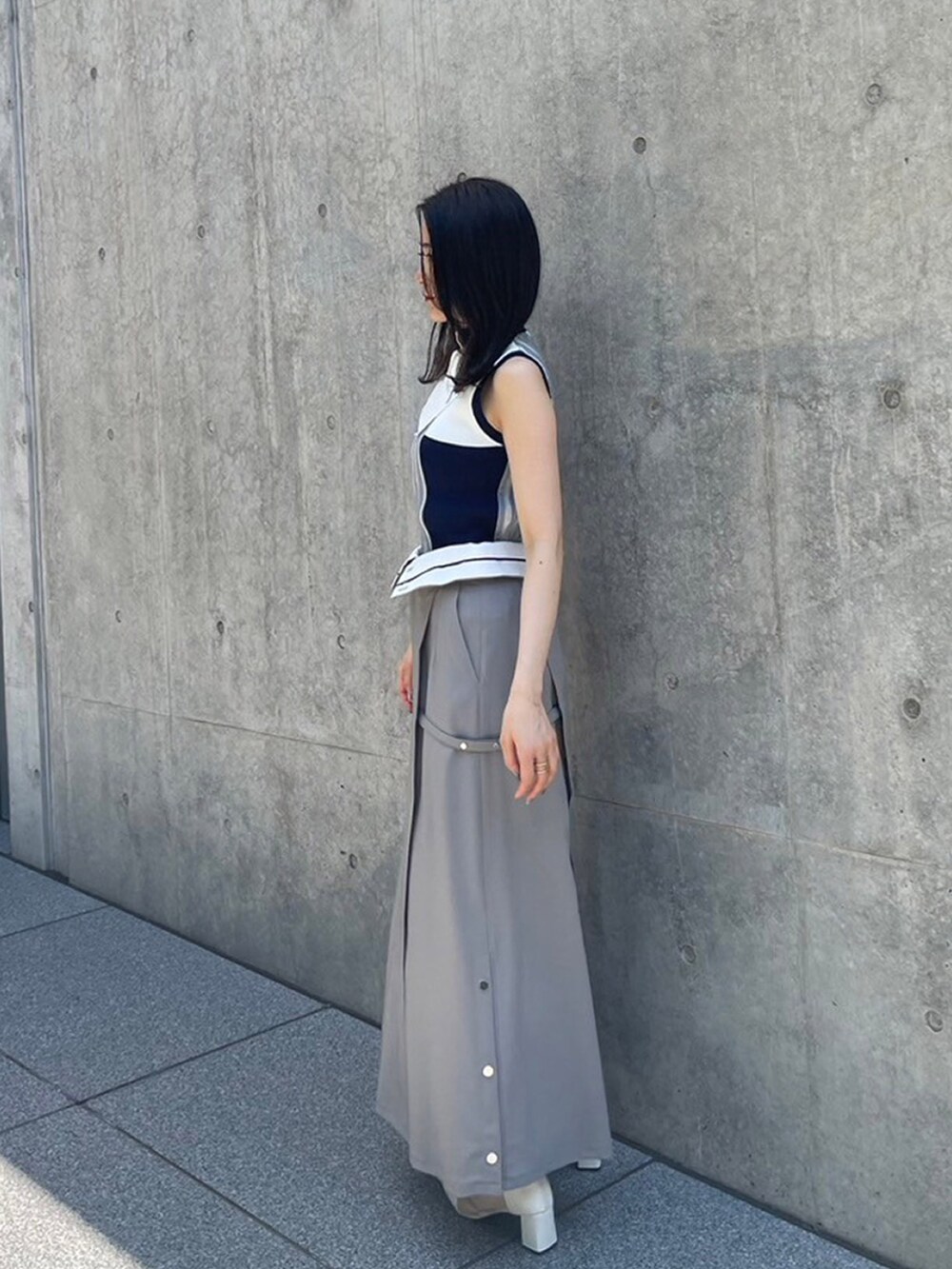 ブルー系のニット/セーター、グレー系のスカートを着用したレディースの夏コーディネートの2枚目の写真