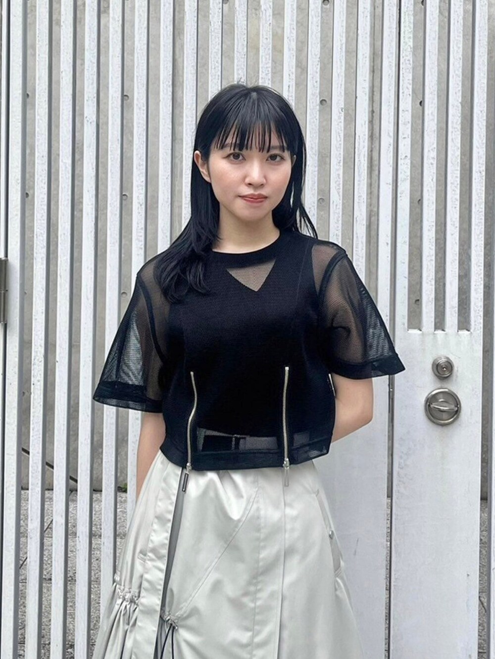 ブラック系のシャツ/ブラウス、ベージュ系のスカート、ブラック系のタンクトップを着用したレディースの春コーディネートの5枚目の写真