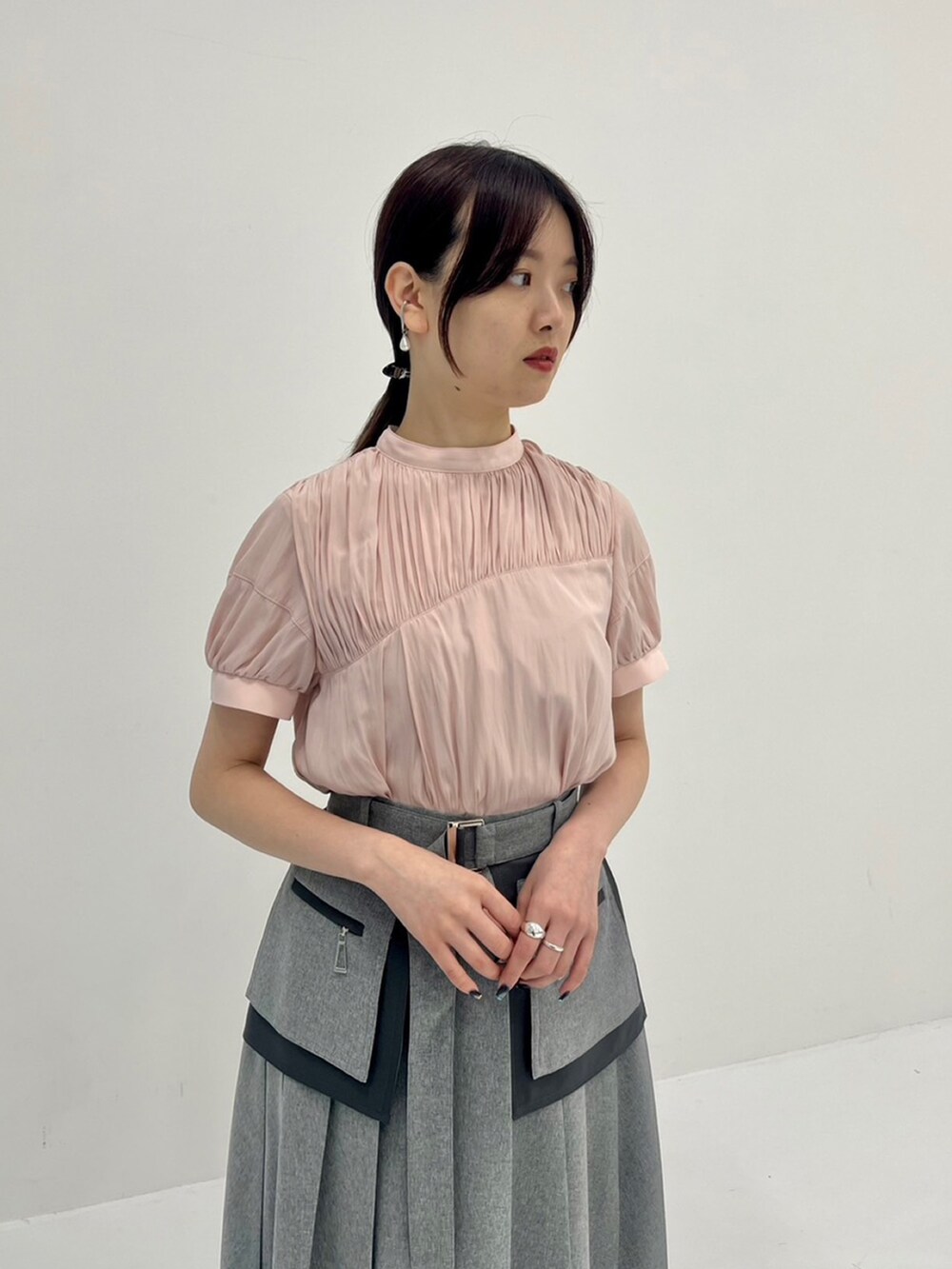 グレー系のスカート、ピンク系のシャツ/ブラウスを着用したレディースの夏コーディネートの2枚目の写真