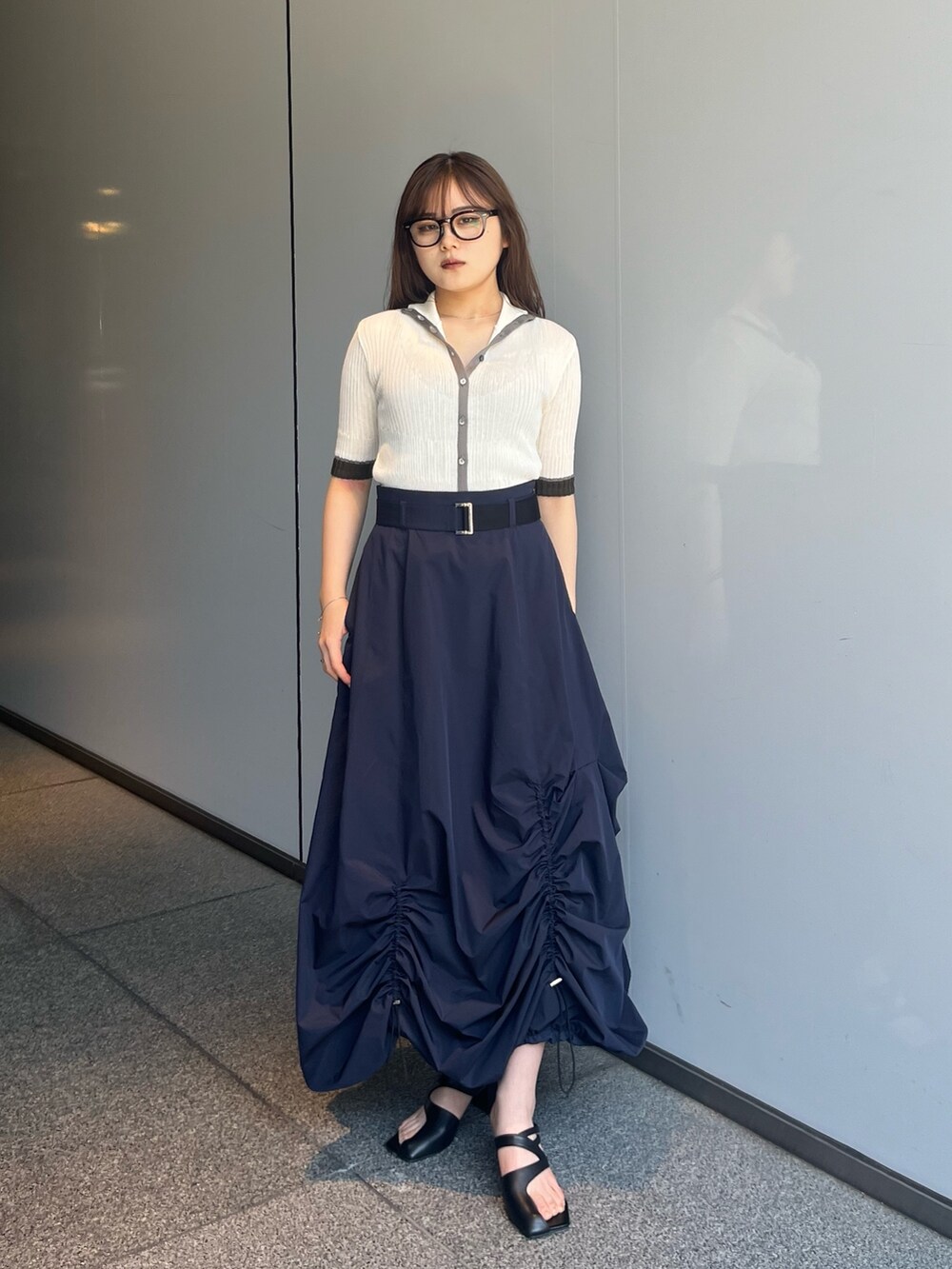 ホワイト系のニット/セーター、ブルー系のスカートを着用したレディースの夏コーディネートの2枚目の写真