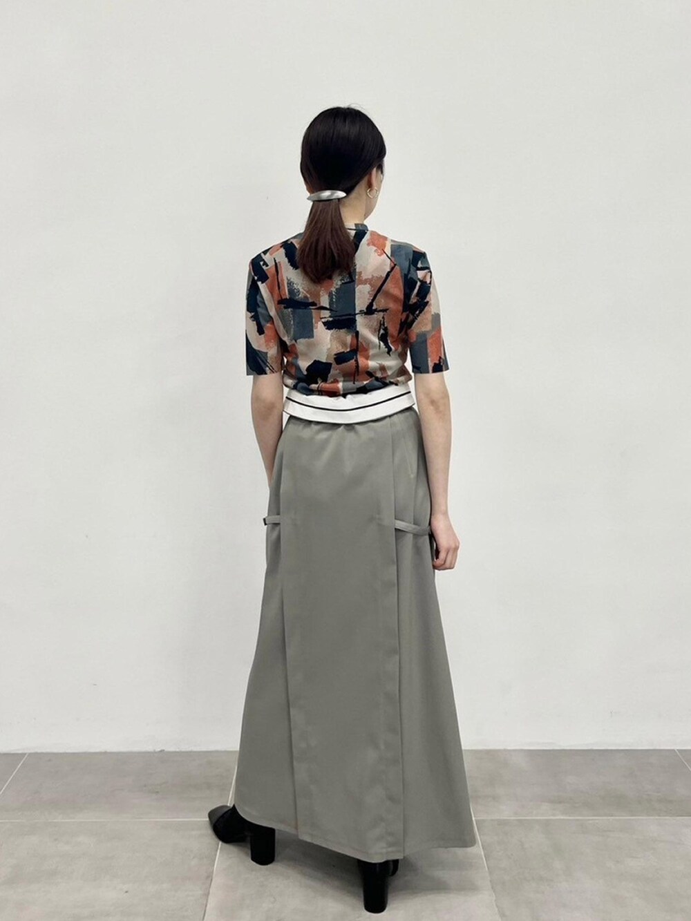 ベージュ系のTシャツ/カットソー、グレー系のスカートを着用したレディースの春コーディネートの2枚目の写真