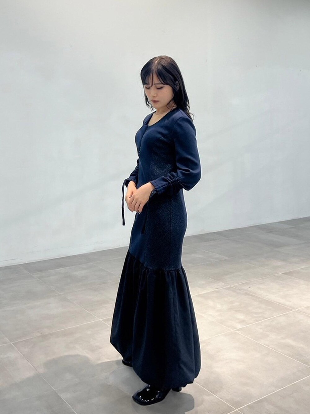 ブルー系のワンピースを着用したレディースの秋コーディネートの2枚目の写真