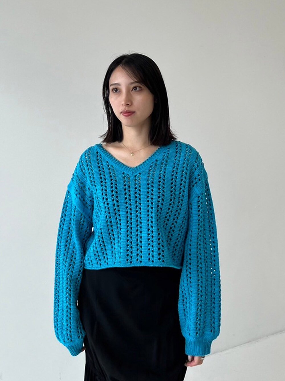 ブルー系のニット/セーター、ブラック系のスカートを着用したレディースの秋コーディネートの4枚目の写真