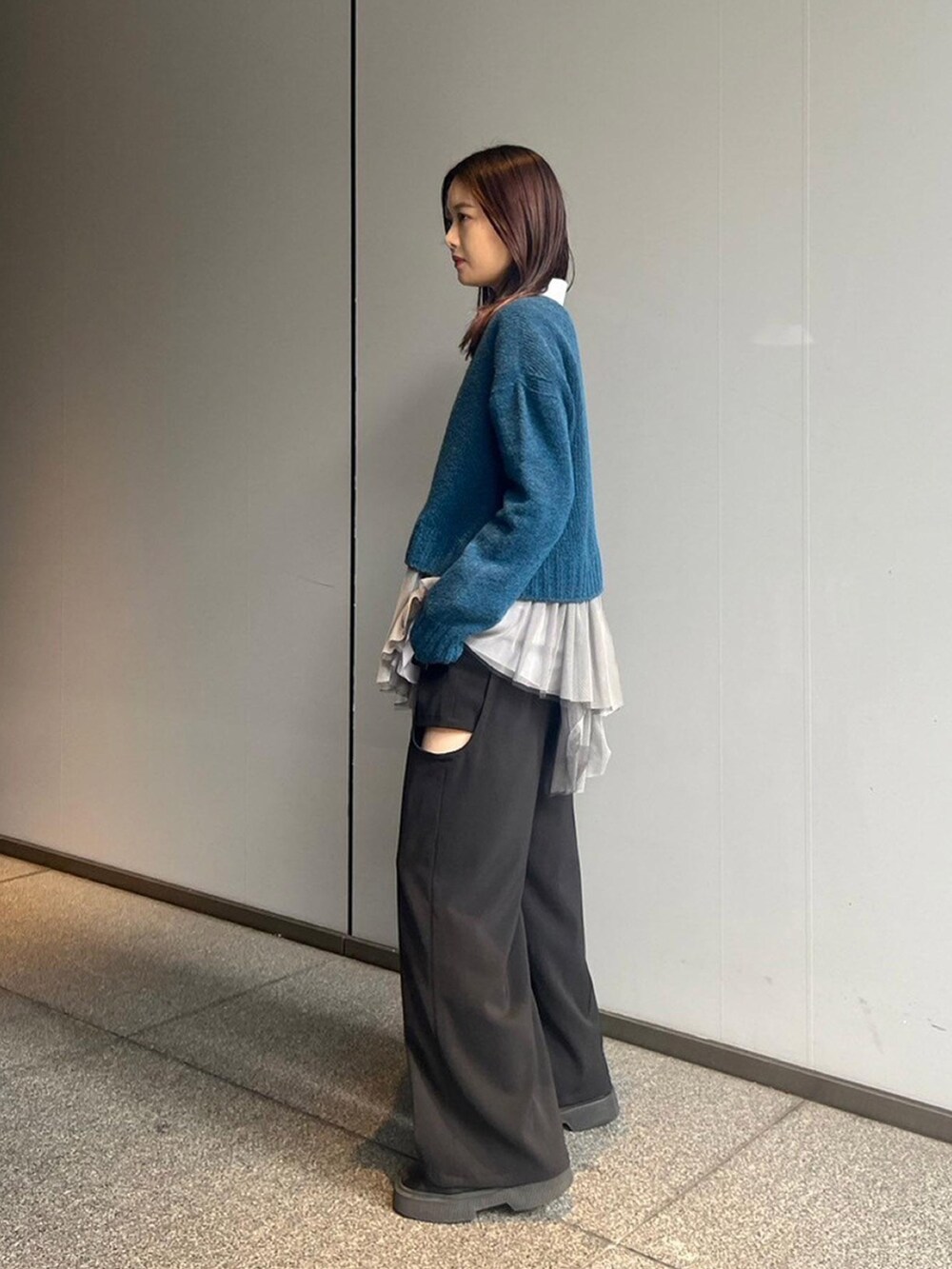 ブルー系のニット/セーター、グレー系のシャツ/ブラウスを着用したレディースの秋コーディネートの2枚目の写真