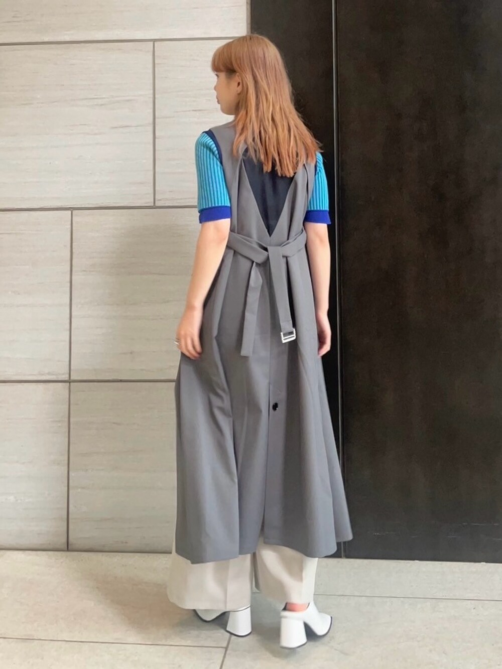 グレー系のジャンパースカートを着用したレディースの春コーディネートの3枚目の写真