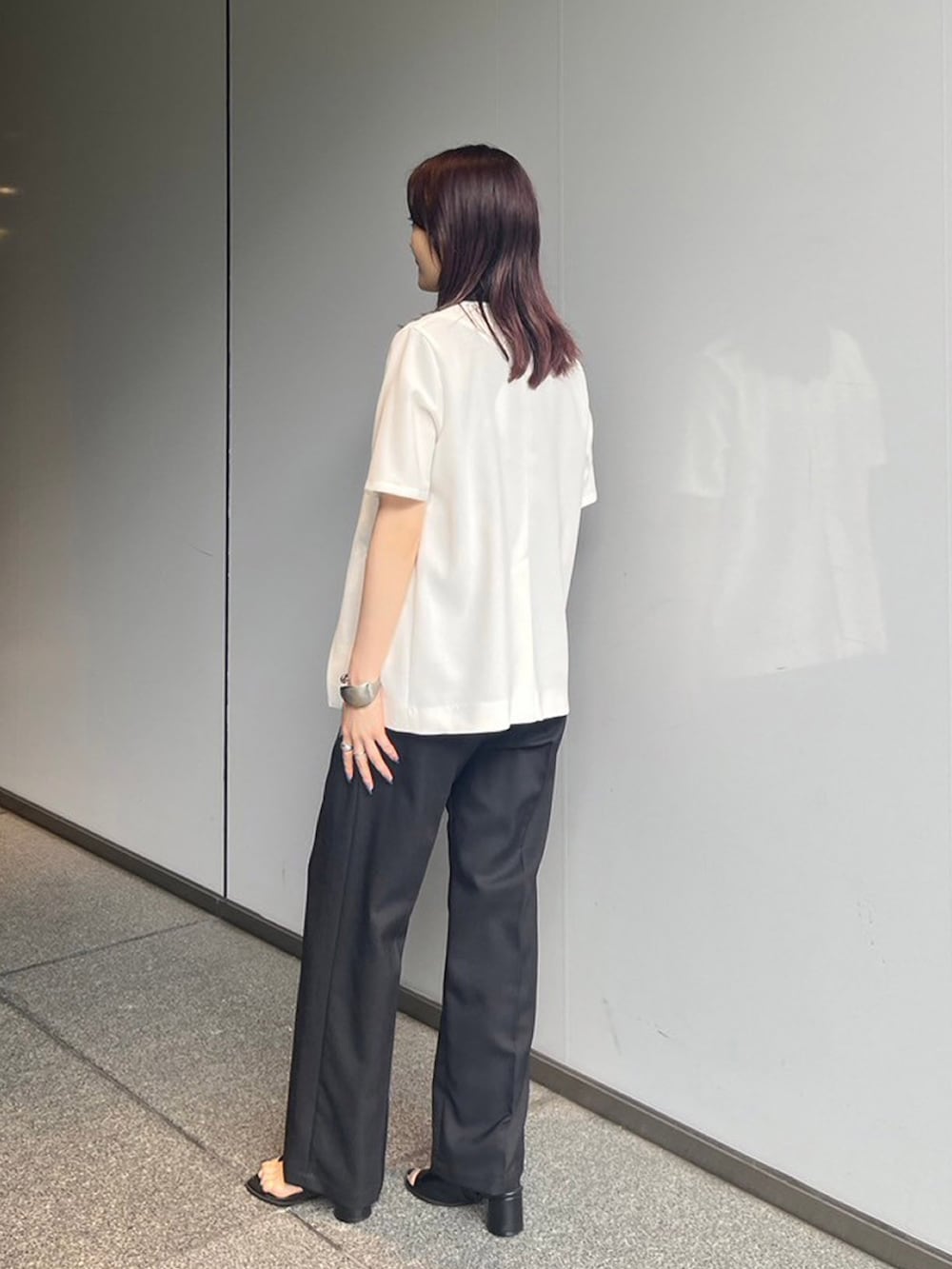 ブラック系のシャツ/ブラウス、ホワイト系のノーカラージャケット、ブラック系のスラックスを着用したレディースの夏コーディネートの2枚目の写真