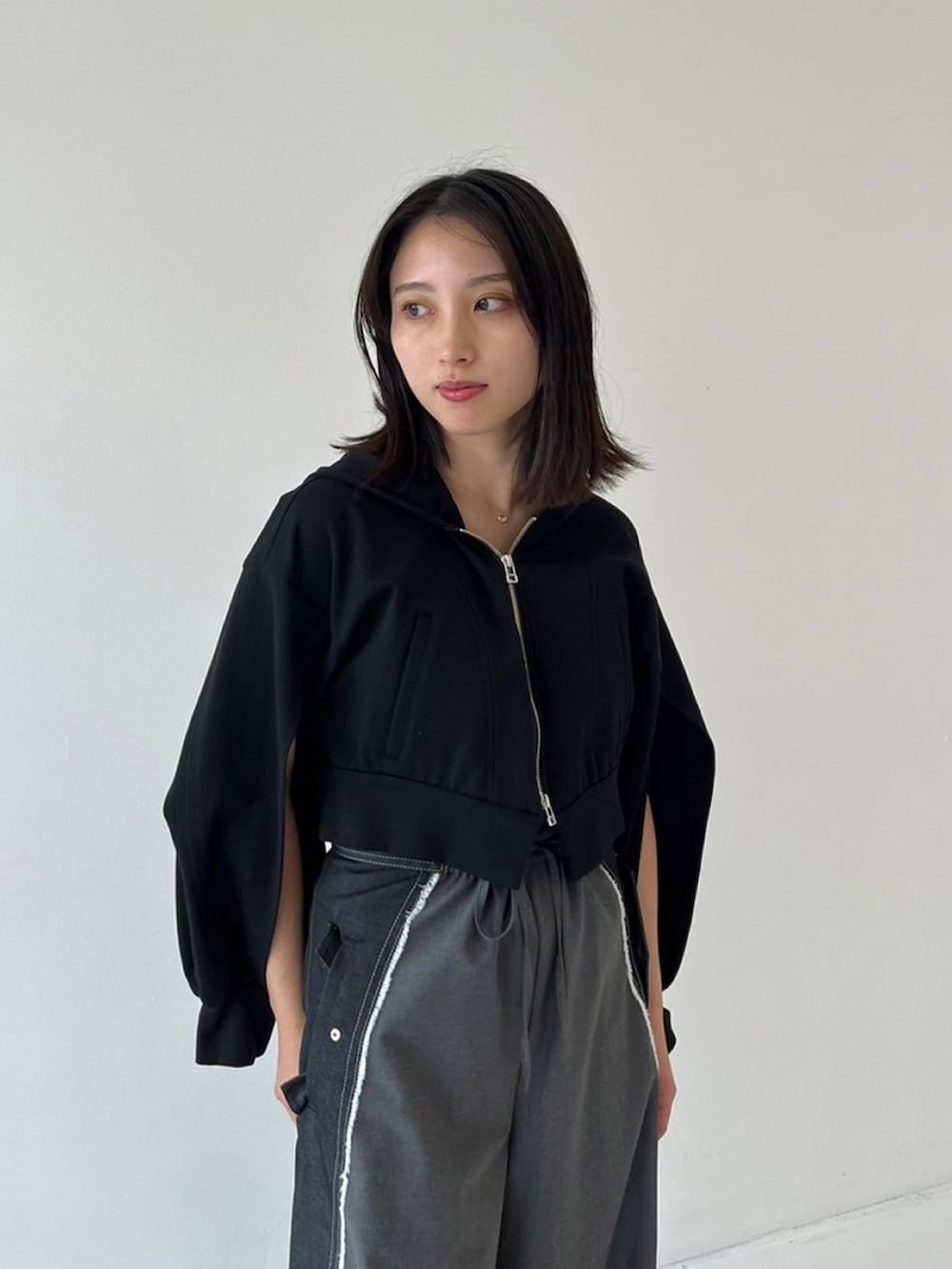 ブラック系のパーカー、ブラック系のデニムパンツを着用したレディースの秋コーディネートの3枚目の写真