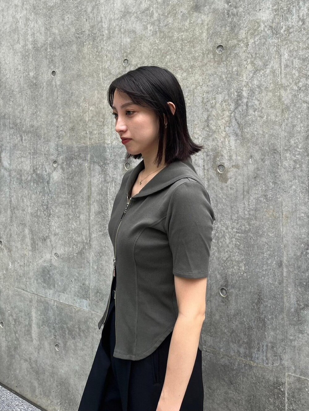 グリーン系のTシャツ/カットソー、ブラック系のスラックスを着用したレディースの夏コーディネートの3枚目の写真
