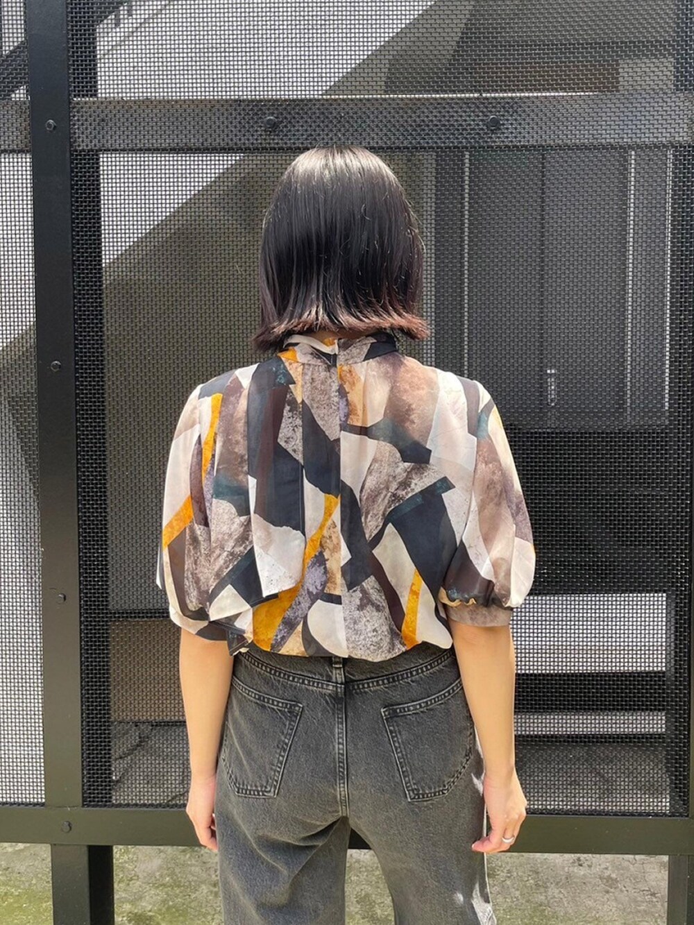 イエロー系のシャツ/ブラウス、ブラック系のデニムパンツを着用したレディースの春コーディネートの6枚目の写真